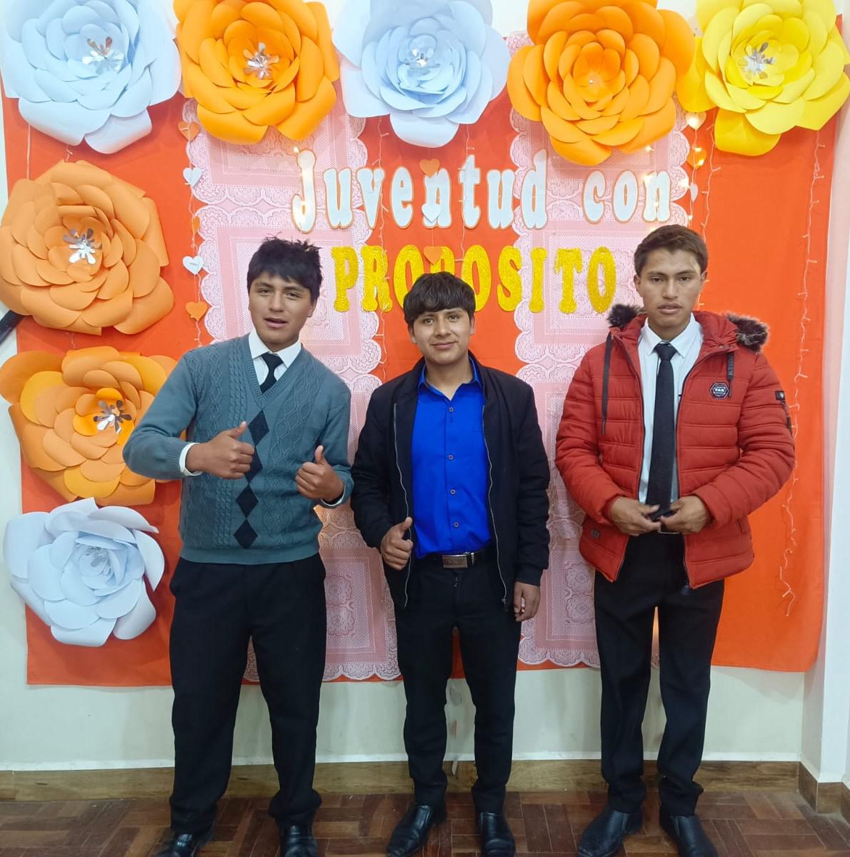 3 young people taking a photo with the frame made by their tutor.
